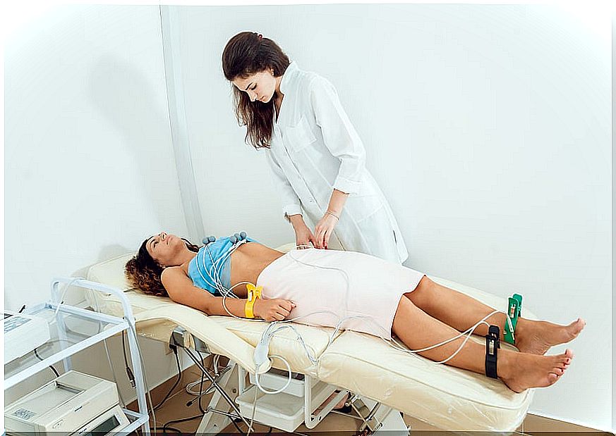 Female doctor doing an electrocardiogram on a female patient.