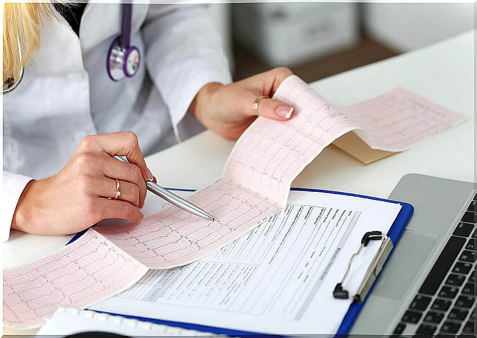 Female doctor examining electrocardiogram results.