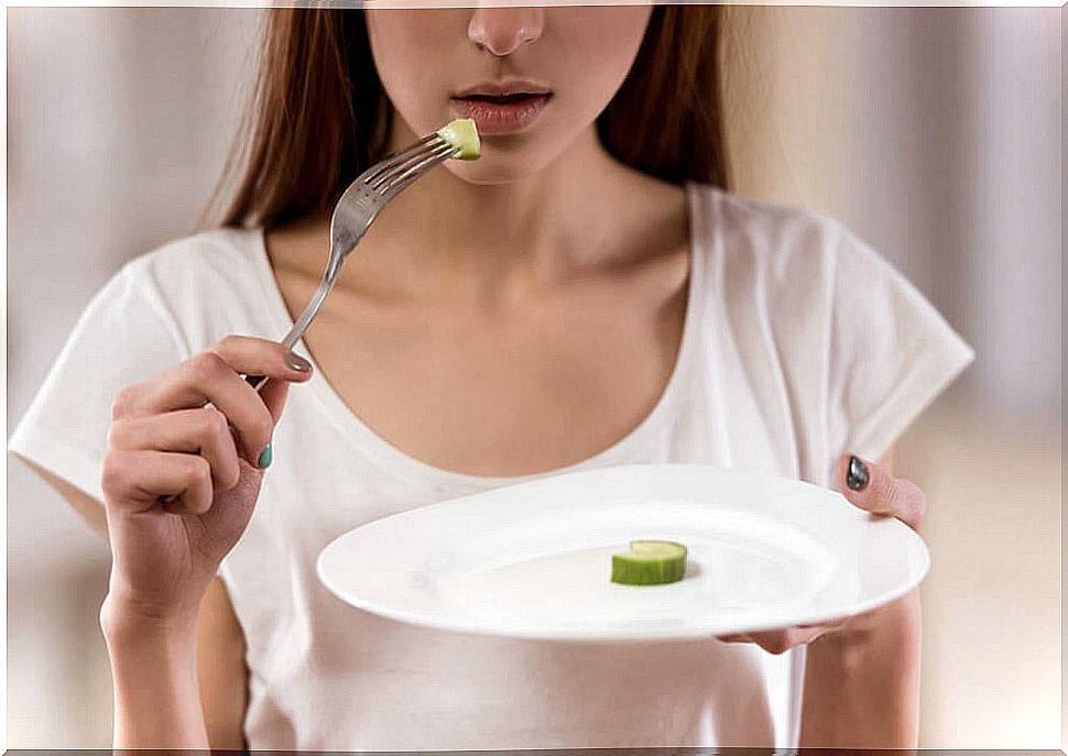 Woman with a plate and a tiny piece of vegetables