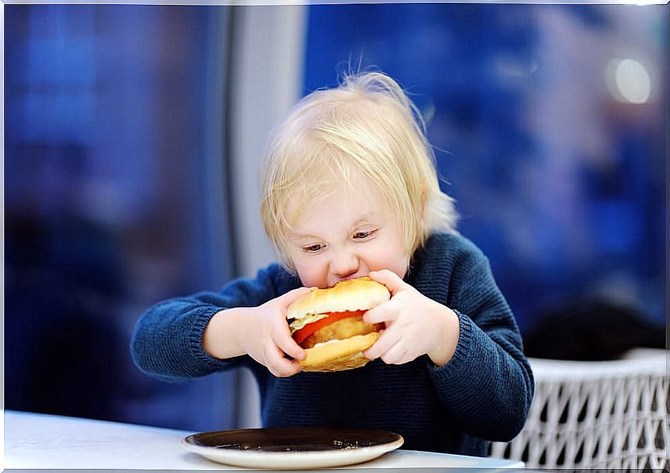 Boy biting a hamburger