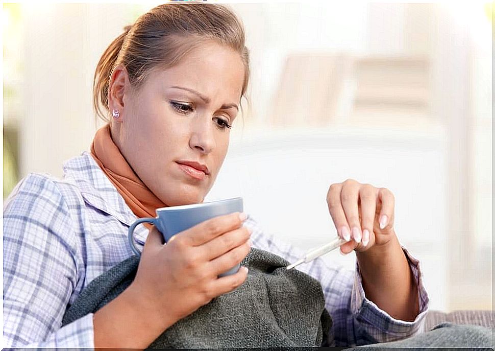 Woman with a cup looking at the thermometer.