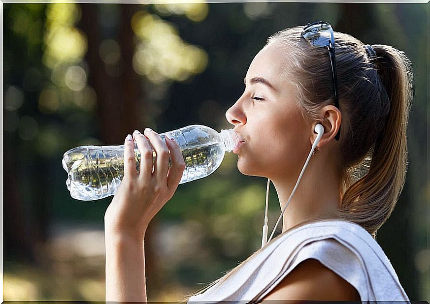 Girl drinking water from a bottle.