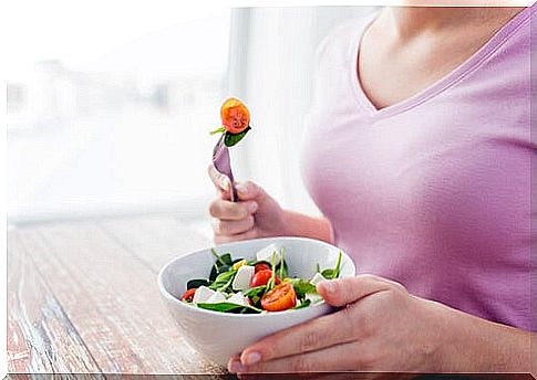 Woman eating a plate of salad